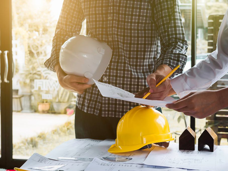 Building workers with plans and hard hats