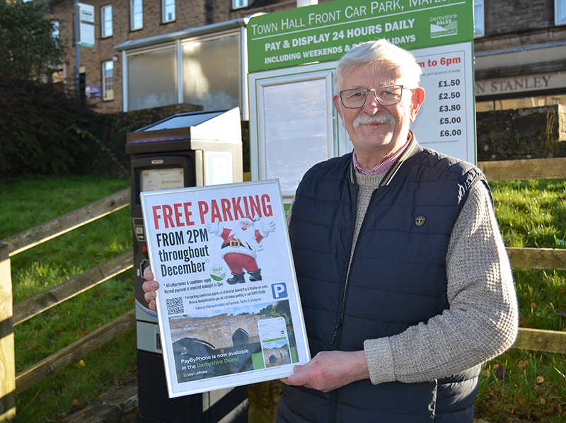 Council leader Councillor Steve Flitter promoting the free parking initiative with a poster at a car park machine